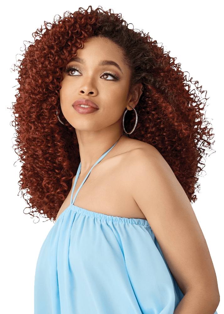 A woman with voluminous, tightly curled auburn hair synthetic half wig